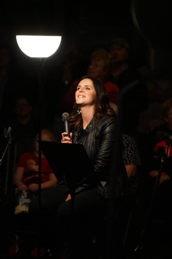 Bethany Hoyt holding a microphone during worship