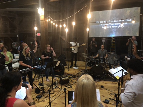 Musicians leading worship with keyboard, guitar, and drums at Albany Worships